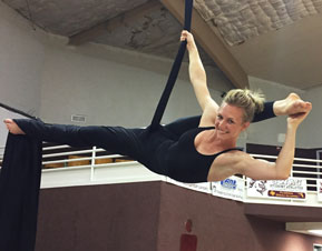 Photo of Danae Songy performing aerial silk acrobatics 