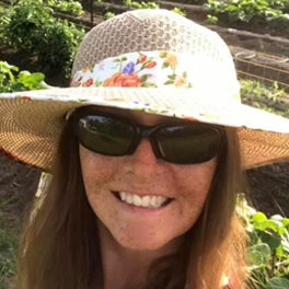 Photo of AIM Member Lora Wishart smiling wearing a sun hat